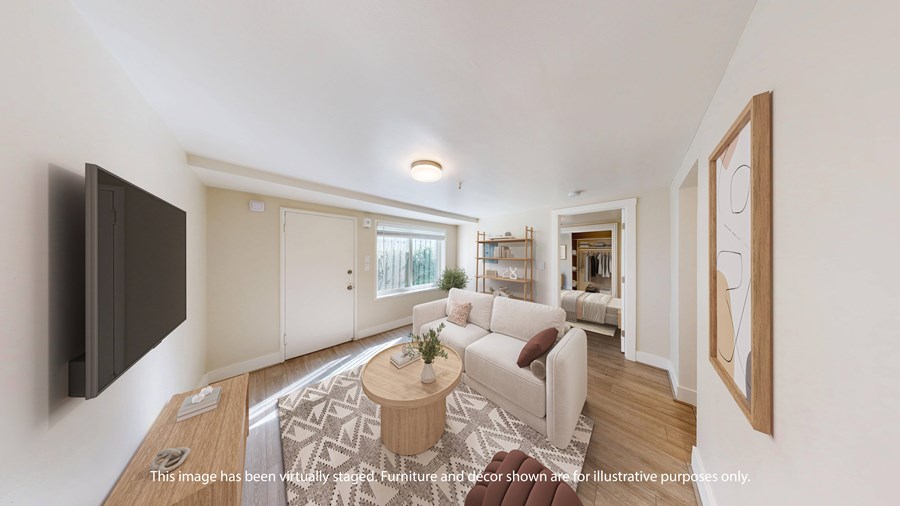 A living room with a white couch and a wooden coffee table.